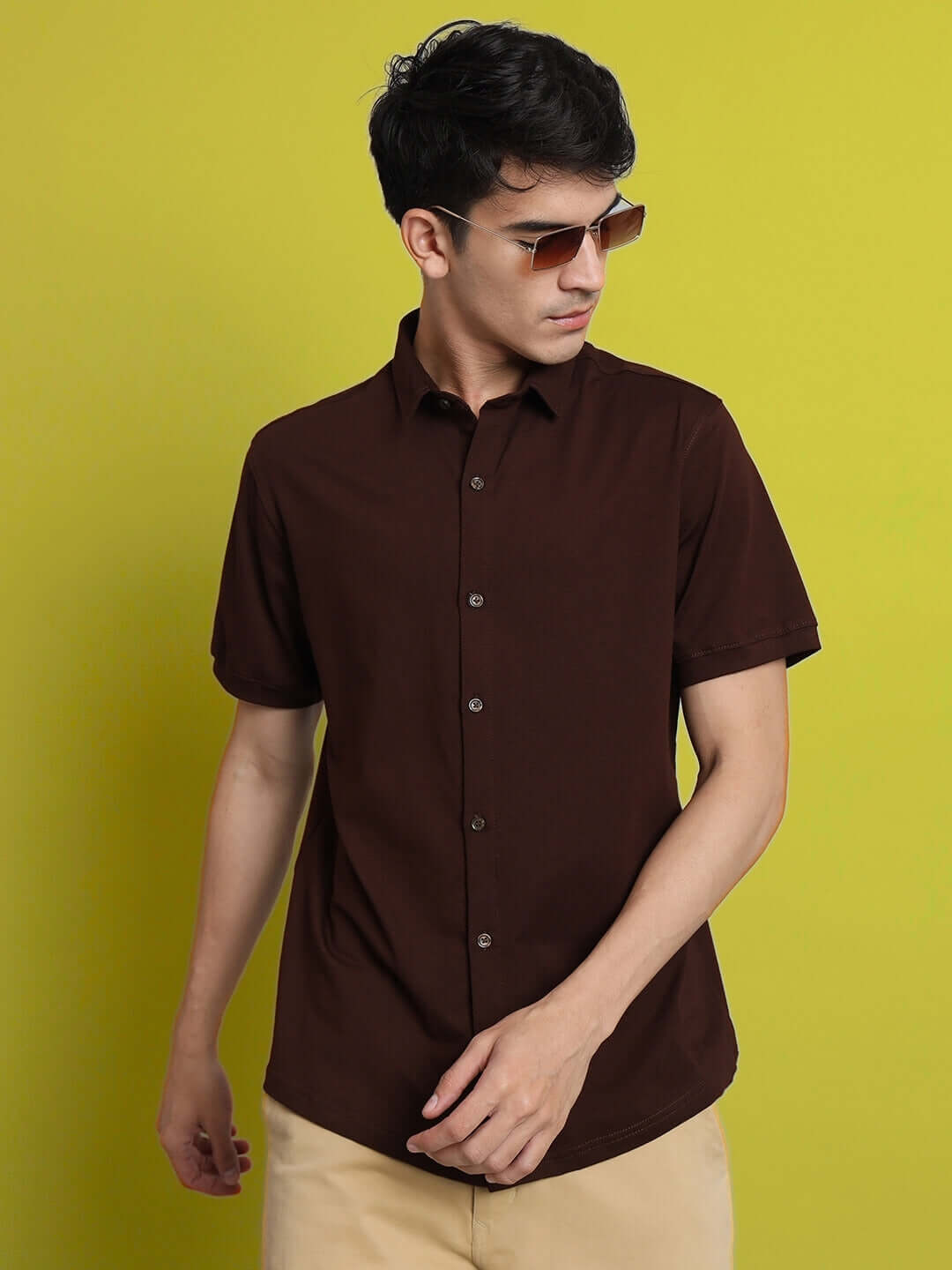 Man wearing a NOIR coffee brown half-sleeve shirt, slim fit, with curved hem and superior stretch, perfect for all day wear.