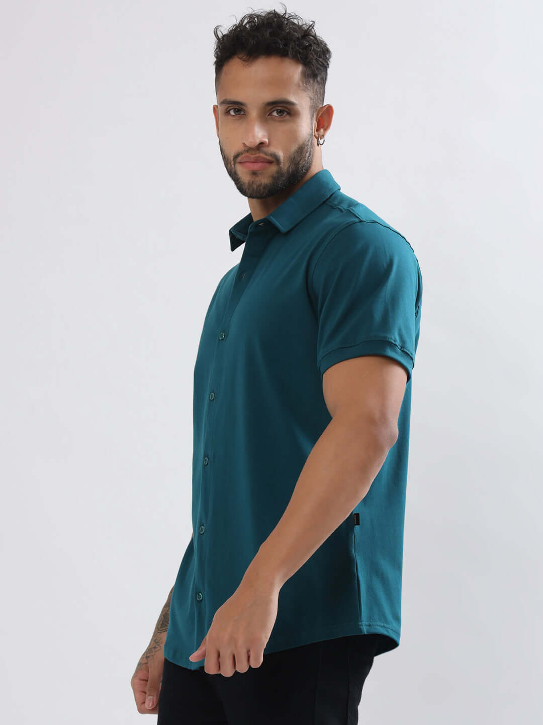Model wearing Noir Teal Blue Shirt, half sleeves, 4-way stretch, wrinkle-free, slim fit, curved hem. Ideal for all-day comfort.