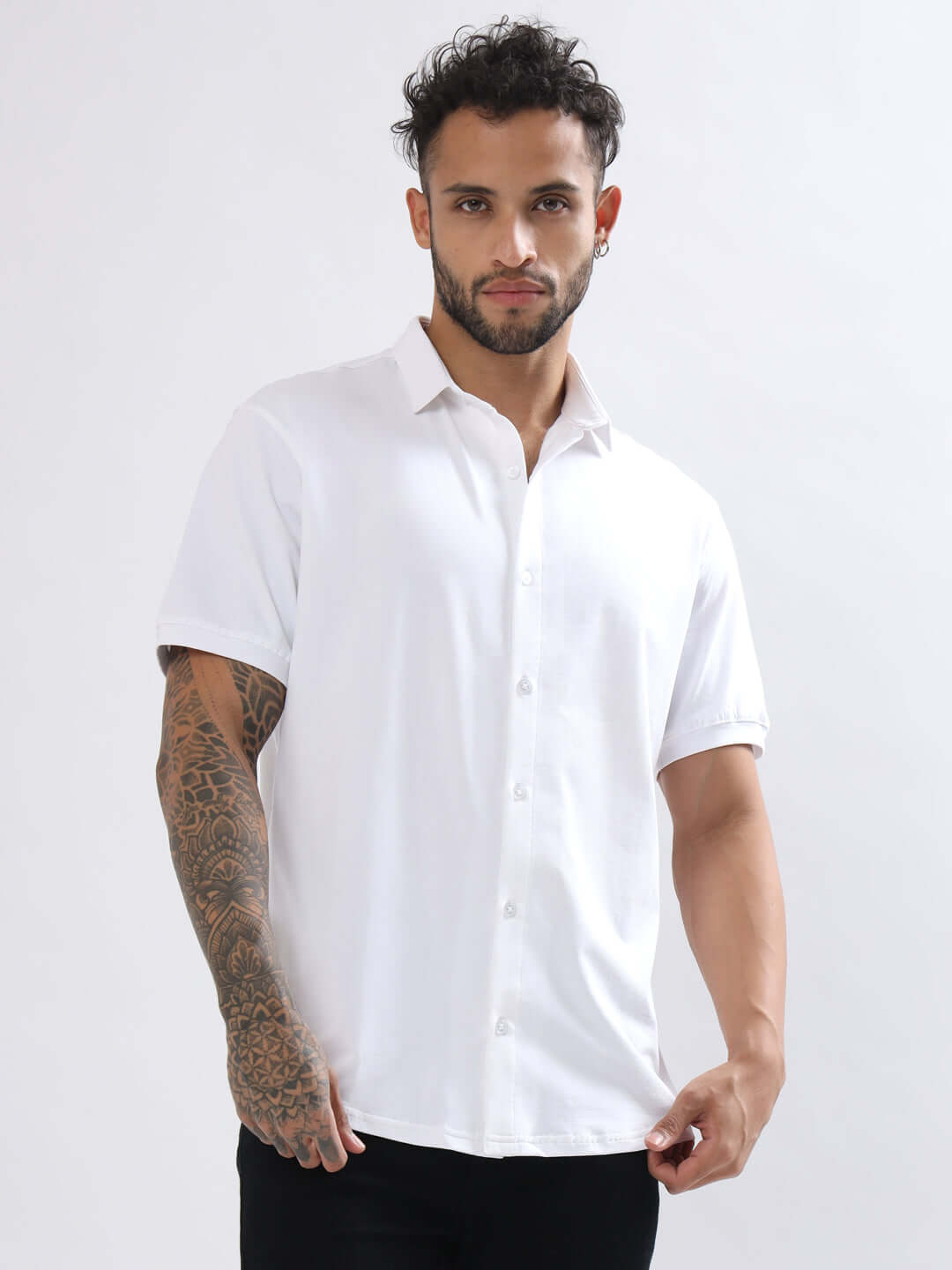 Model wearing a NOIR white half-sleeve stretch shirt, wrinkle-free, slim fit, with curved hem, made from 100% cotton lycra.