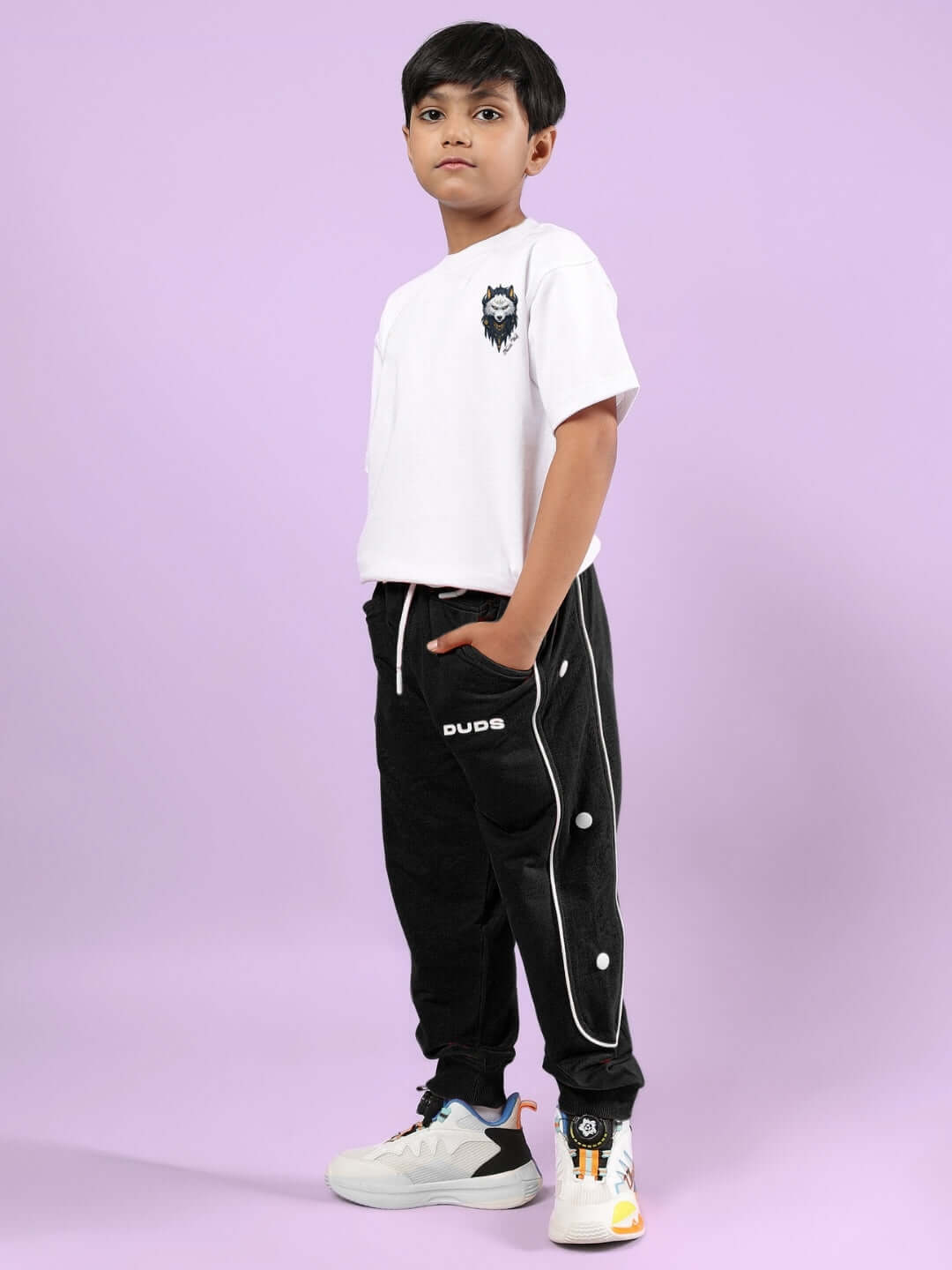 Child wearing NORDIC WOLF CO-ORD FOR BOYS & GIRLS WHITE-BLACK outfit by DUDS against a purple background.