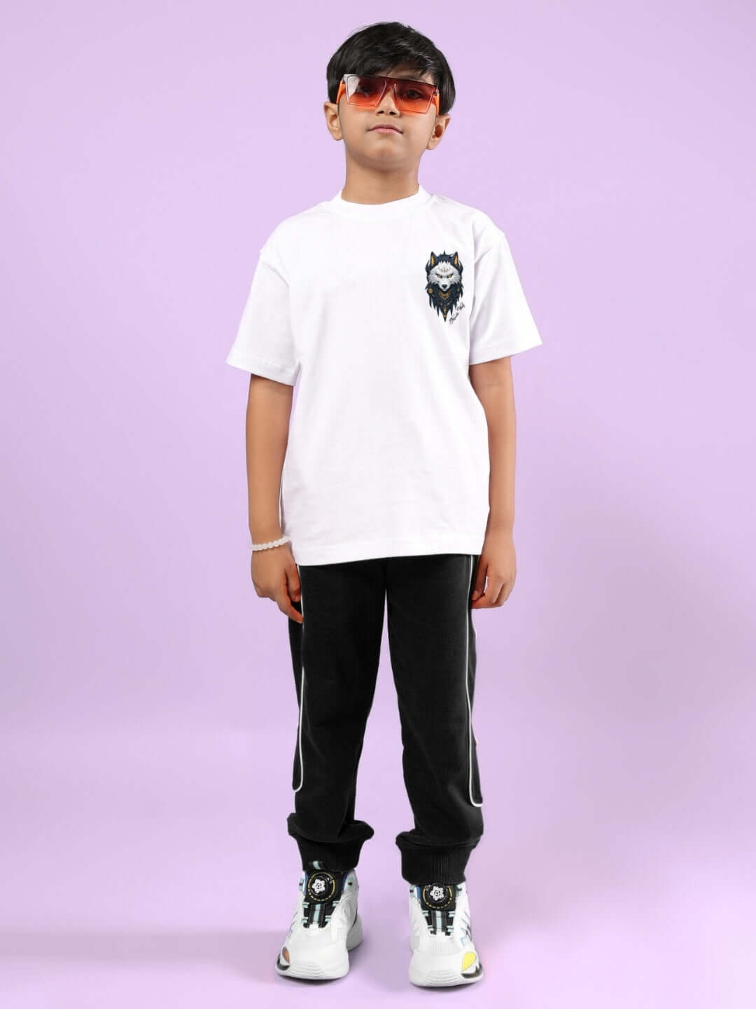 Child wearing NORDIC WOLF CO-ORD FOR BOYS & GIRLS WHITE-BLACK outfit with black pants and a white shirt against a purple background.