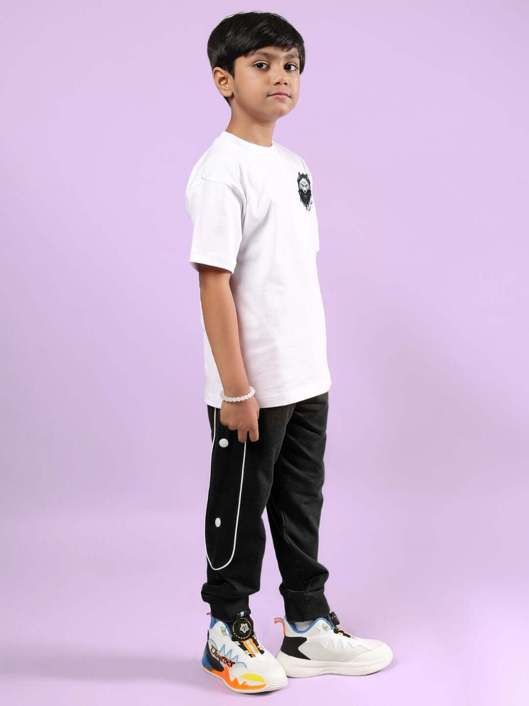 Child wearing NORDIC WOLF CO-ORD FOR BOYS & GIRLS WHITE-BLACK outfit, standing on purple background.