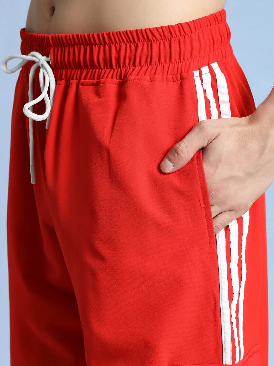 Close-up of NOVA RELAXED FIT CARGO PANTS RED highlighting side pocket and white drawstring.