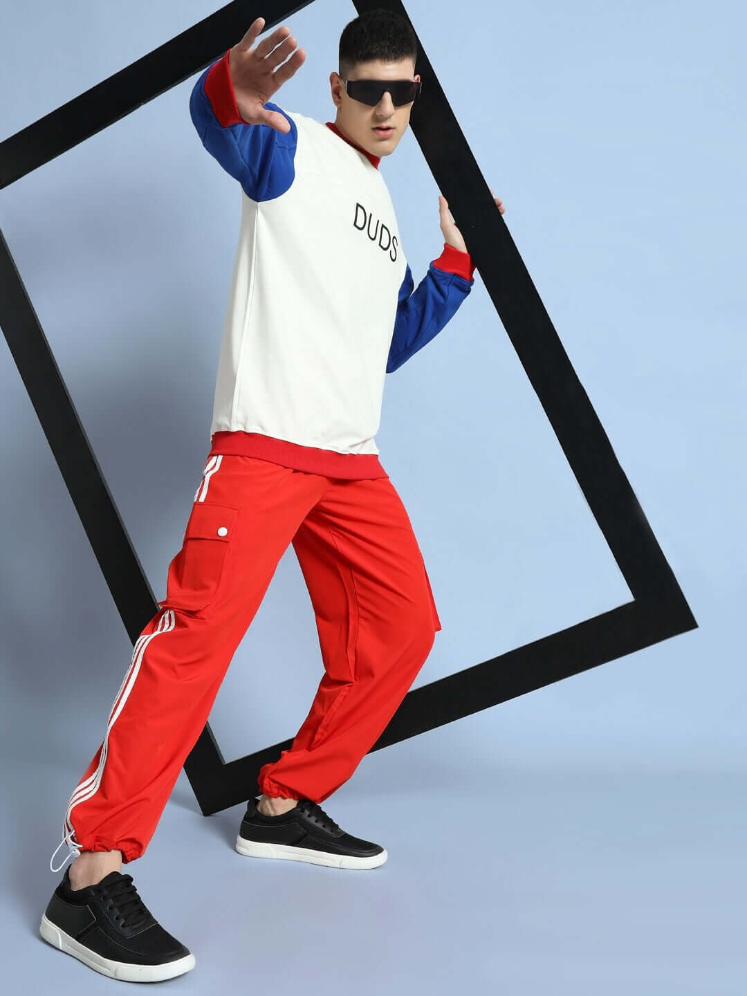 Model wearing NOVA RELAXED FIT CARGO PANTS RED with cargo pockets, showcasing streetwear style.