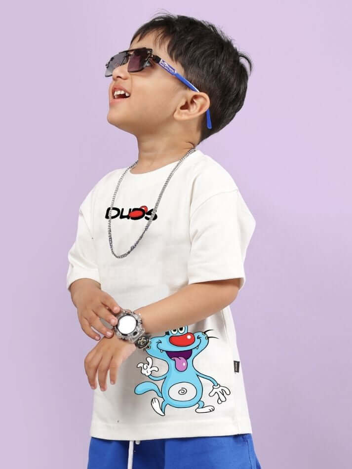 Child wearing OGGY PRINTED T-SHIRT FOR BOYS AND GIRLS OFF WHITE, featuring cartoon character graphic and chain accessories.