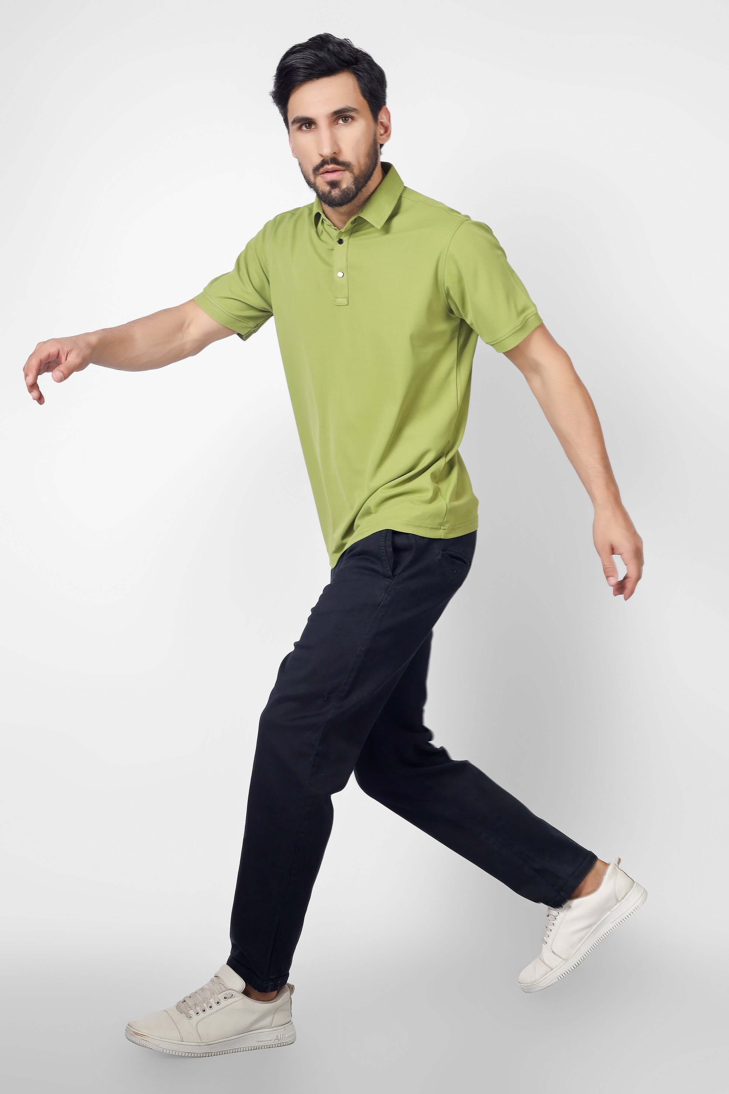 Man wearing olive green polo neck t-shirt, half sleeves, slim fit, with metal button, showcasing wrinkle-free polyester fabric.