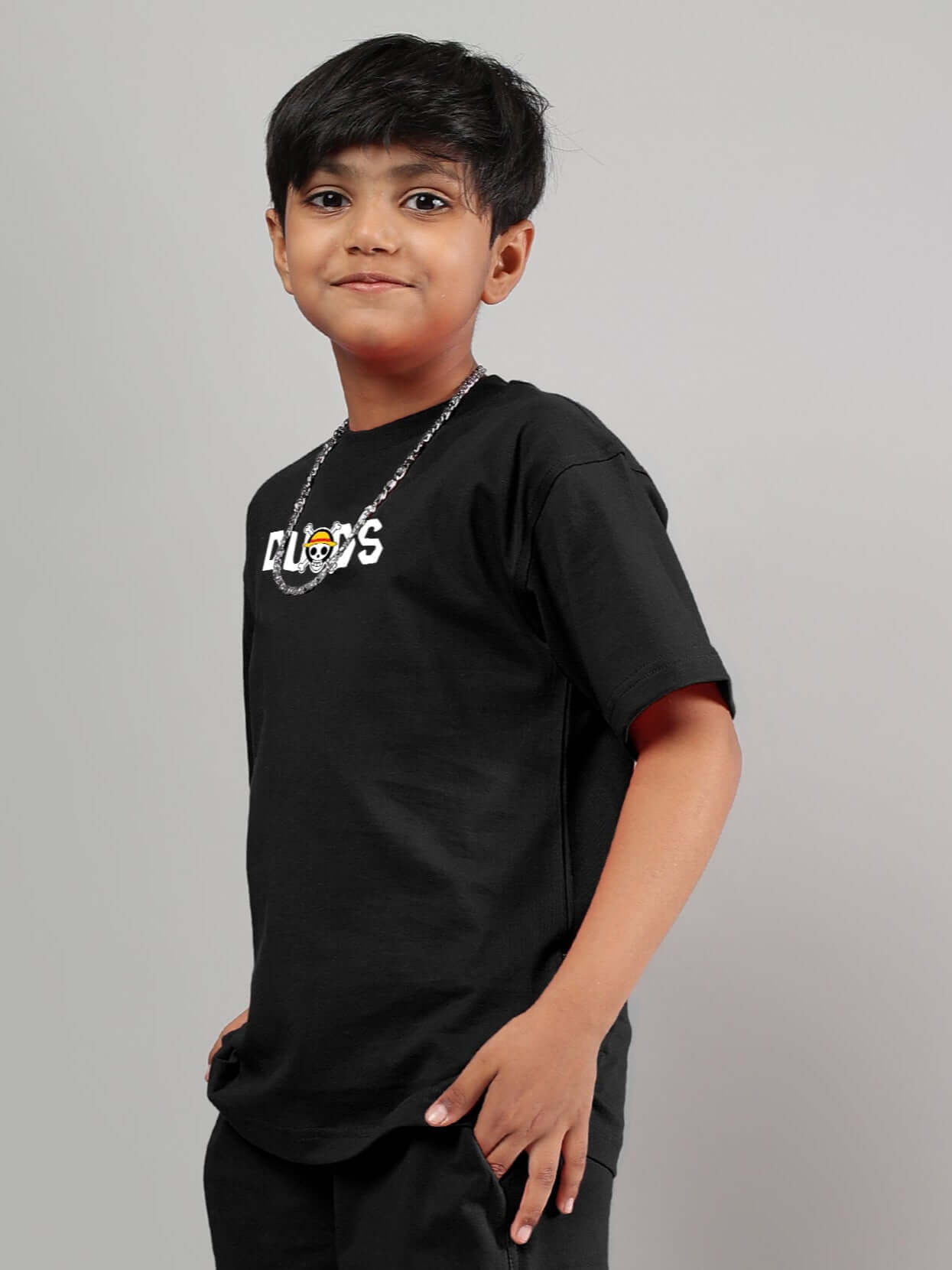 Young boy wearing a black One Piece t-shirt with logo, suitable for boys and girls, made by DUDS.
