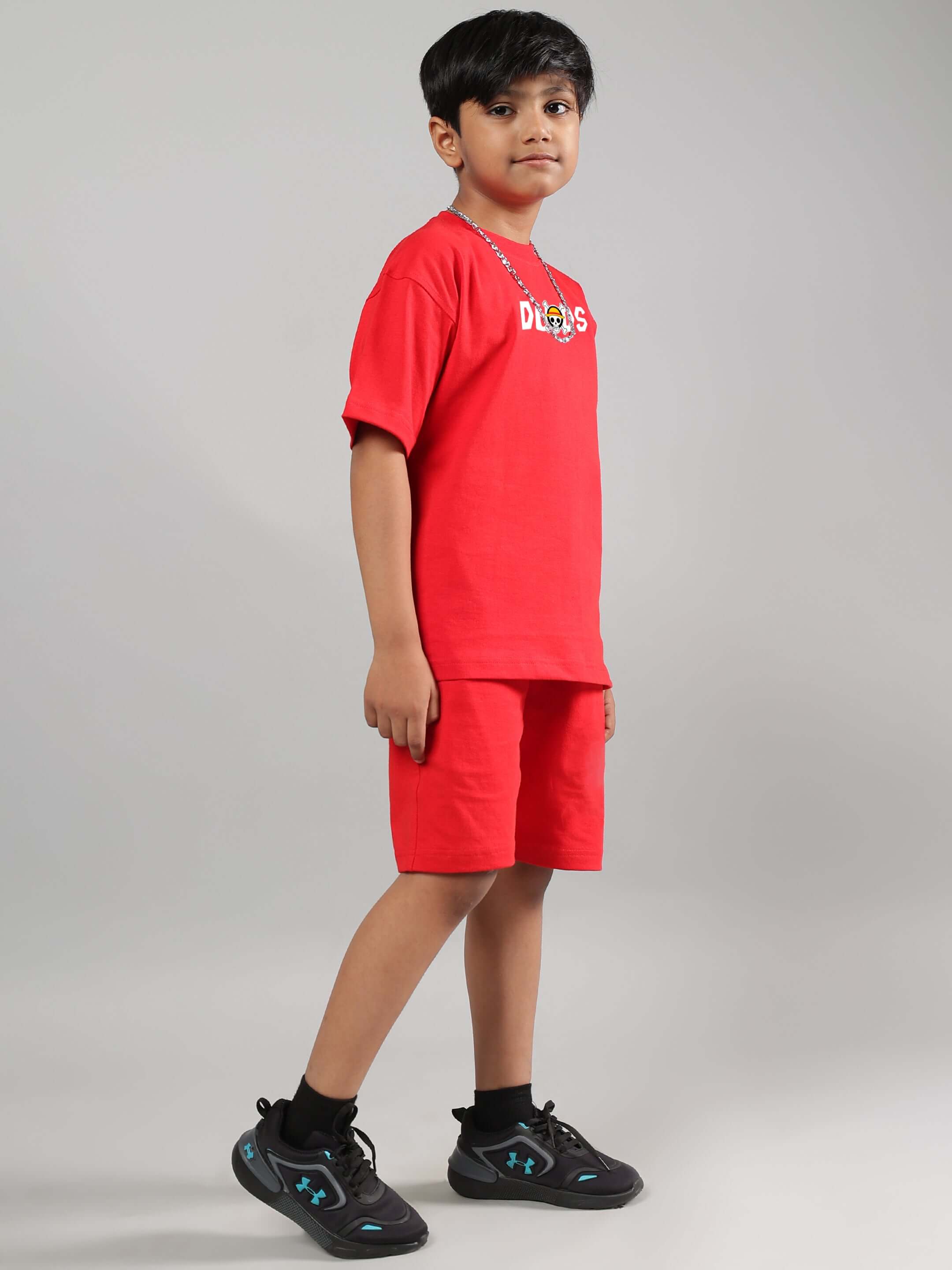 Boy wearing a red ONE PIECE summer co-ord set from DUDS, tailored for both boys and girls. Made-to-order for a perfect fit.