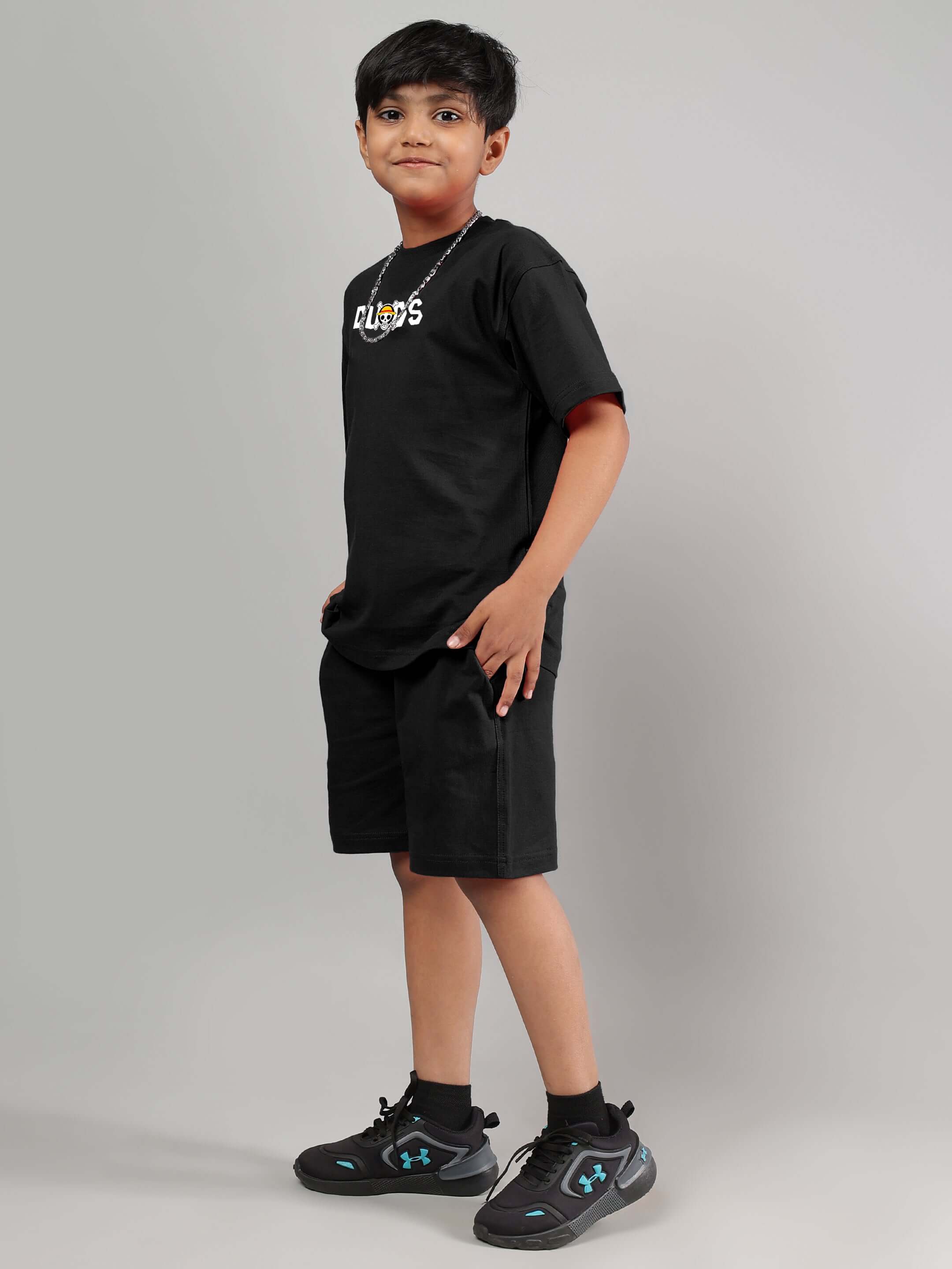 Boy wearing black ONE PIECE summer co-ord set by DUDS, suitable for boys and girls, customizable sizing option available.
