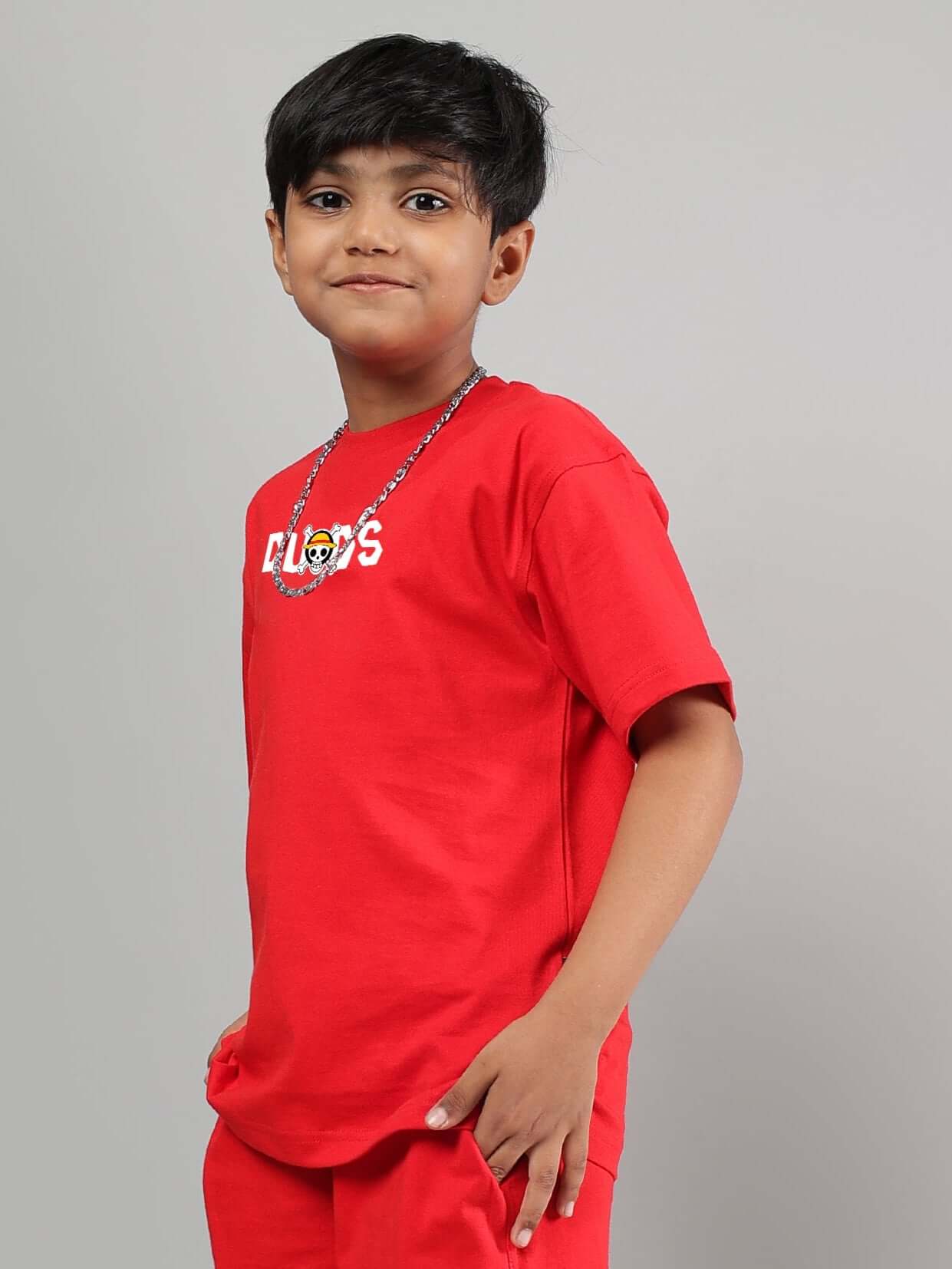 Boy wearing a red One Piece t-shirt from DUDS, showcasing a casual style. Perfect for boys and girls, custom fit options available.