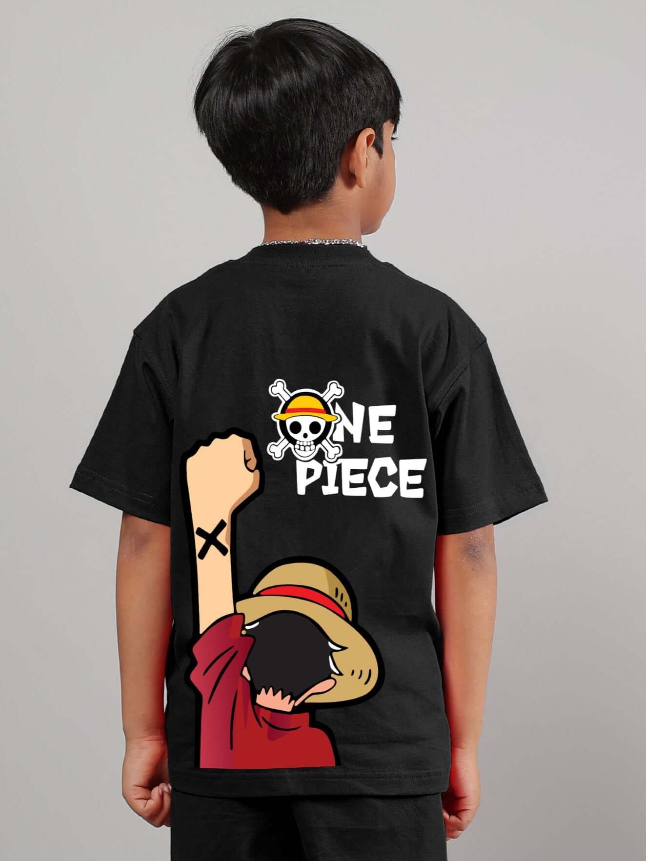 Back view of child wearing a black One Piece T-shirt featuring the iconic logo and character, suitable for boys and girls. Made by DUDS.