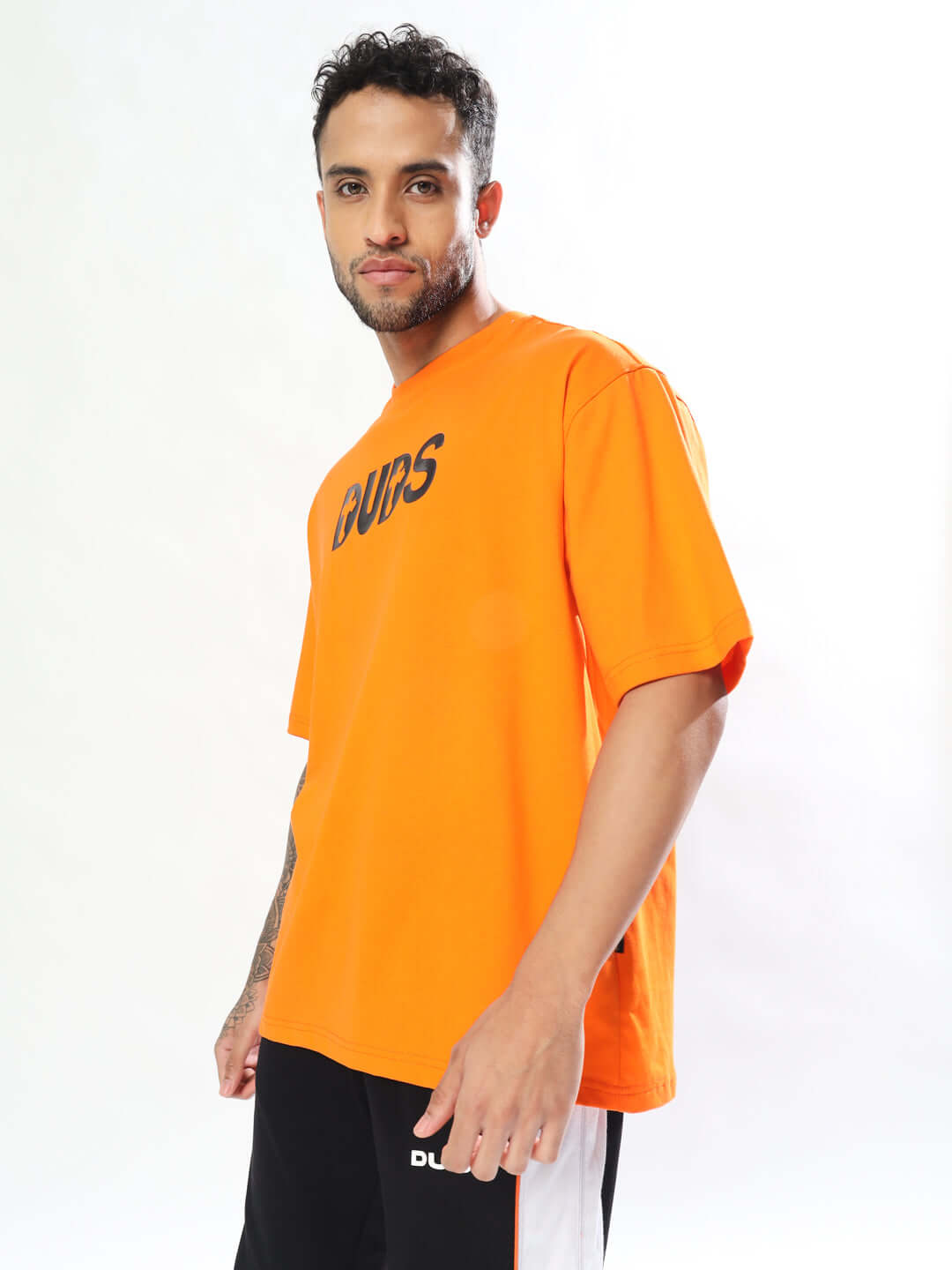 Man wearing orange oversized t-shirt with 'ONLY GOD CAN JUDGE ME' text, made from premium cotton fabric.