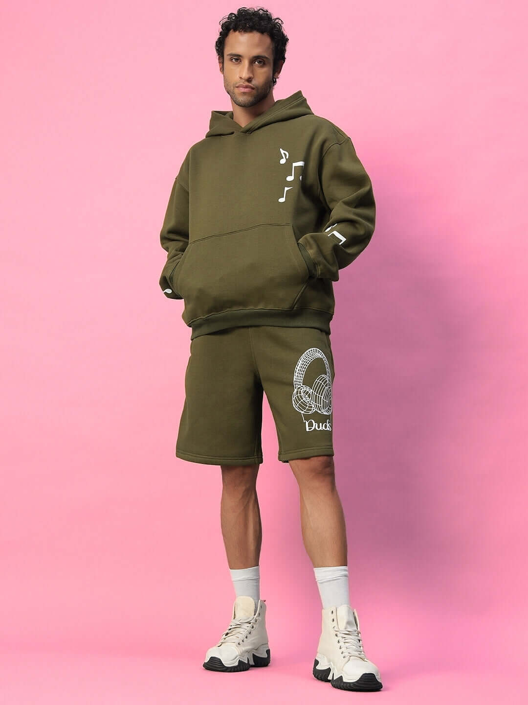 Model wearing OPERA FLEECE CO-ORD OLIVE GREEN outfit, featuring hoodie and shorts, with design details by DUDS.