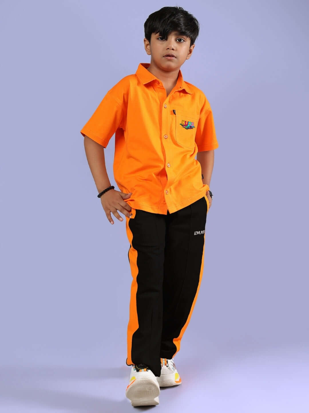 Child wearing EVERY DAY CO-ORD FOR BOYS & GIRLS ORANGE BLACK outfit featuring orange shirt and black pants with orange stripe.