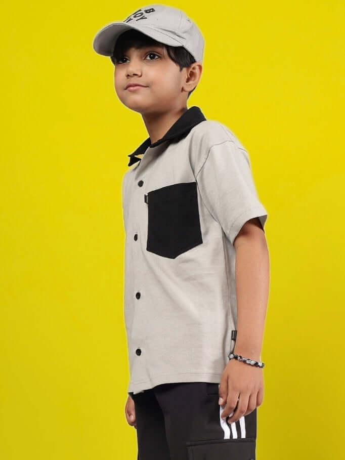 Alt Tag: Child wearing an Orion Shirt for Boys & Girls in grey-black, showcasing custom fit options by DUDS against a yellow background.