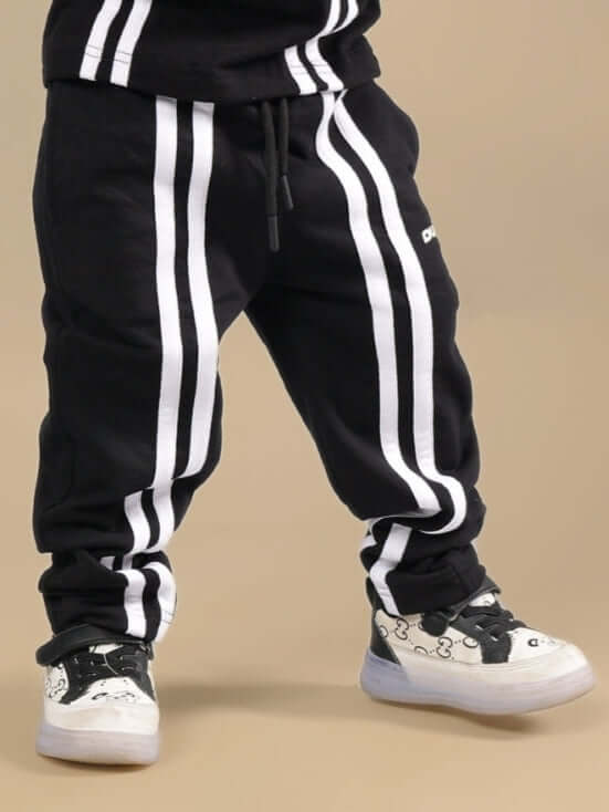 Child wearing OUTLOOK JOGGER FOR BOYS GIRLS BLACK with striped design, ideal for active days and casual wear.