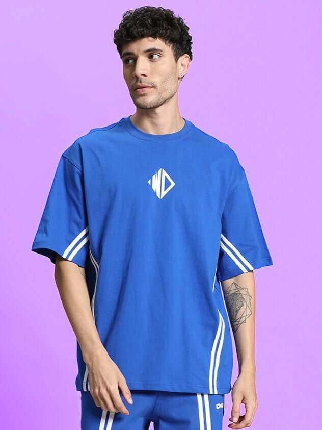 Model wearing OUTLOOK OVER-SIZED T-SHIRT ROYAL BLUE with bold royal blue shade in a relaxed, modern streetwear style.