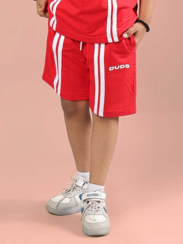 Child wearing OUTLOOK SHORTS FOR BOYS GIRLS RED showcasing regular fit and breathable fabric for active wear.