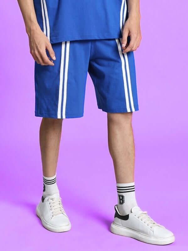 Person wearing OUTLOOK REGULAR FIT SHORTS ROYAL BLUE with white stripes, showcasing vibrant style and comfortable fit.