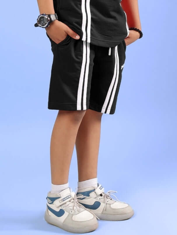 Child wearing OUTLOOK SHORTS FOR BOYS GIRLS BLACK with sneakers, showing athletic style and comfort.