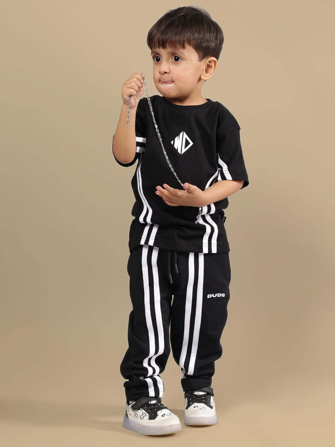 Child wearing OUTLOOK SUMMER CO-ORD SET FOR BOYS GIRLS BLACK with striped design, showcasing stylish comfort and versatility.