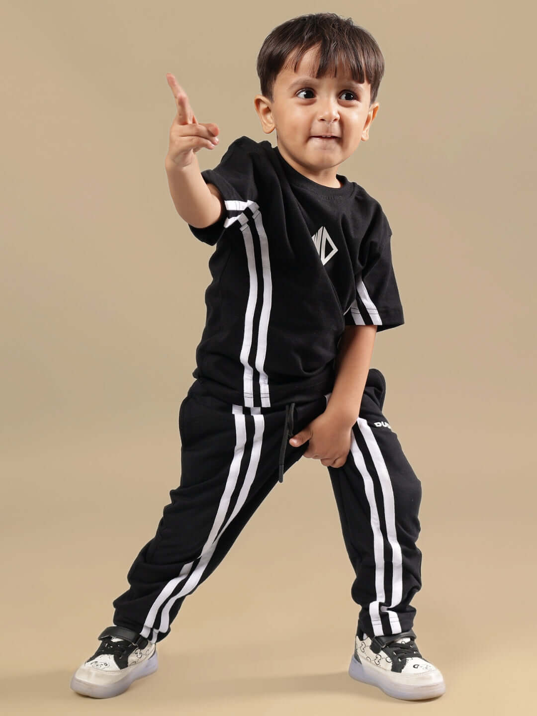 Child wearing black OUTLOOK summer co-ord set with white stripes, posing playfully. Perfect for boys and girls. Custom size available.