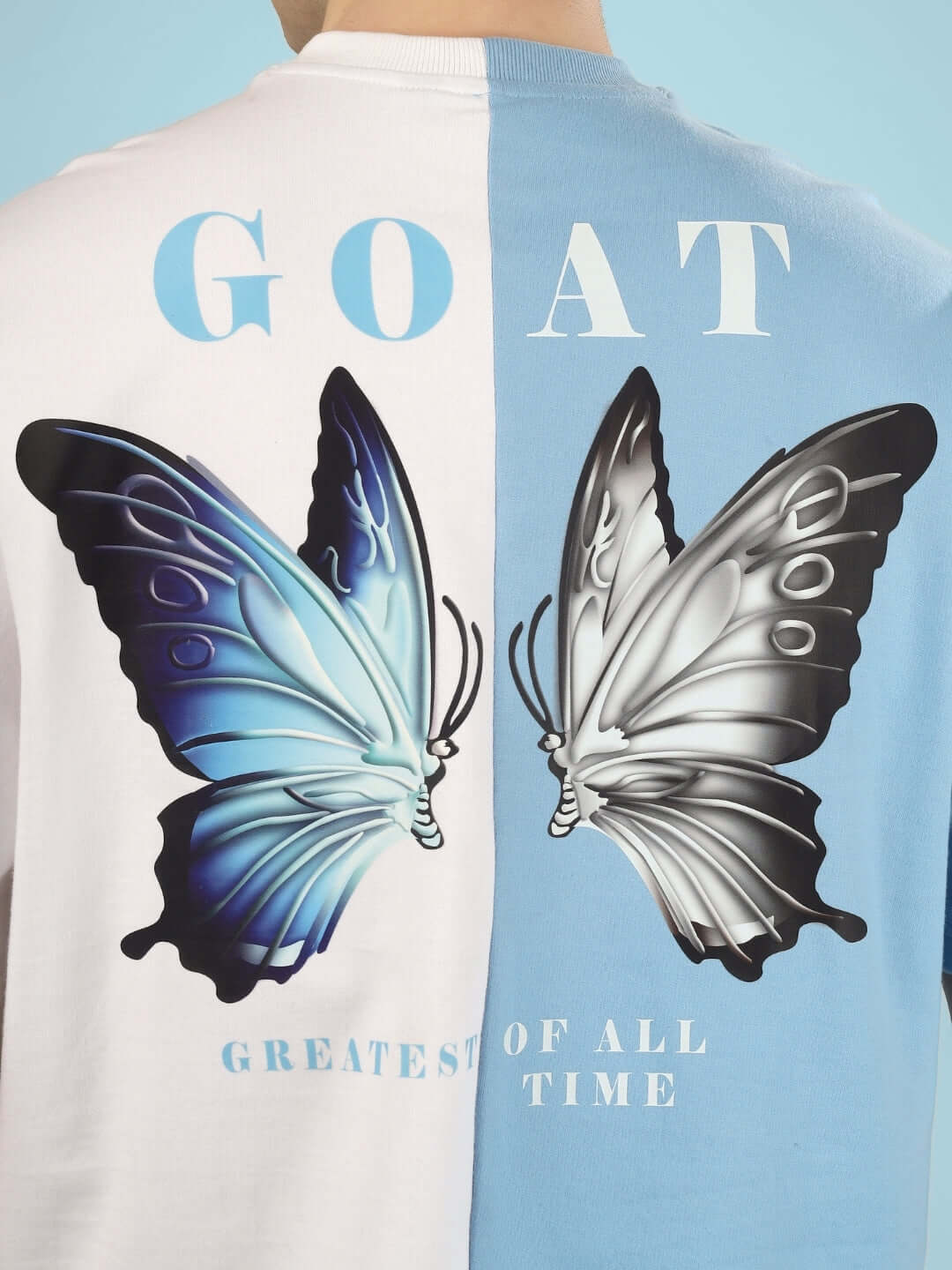 Sky blue and white G.O.A.T oversized T-shirt with butterfly design, crafted from premium cotton French terry, perfect for stylish casual wear.