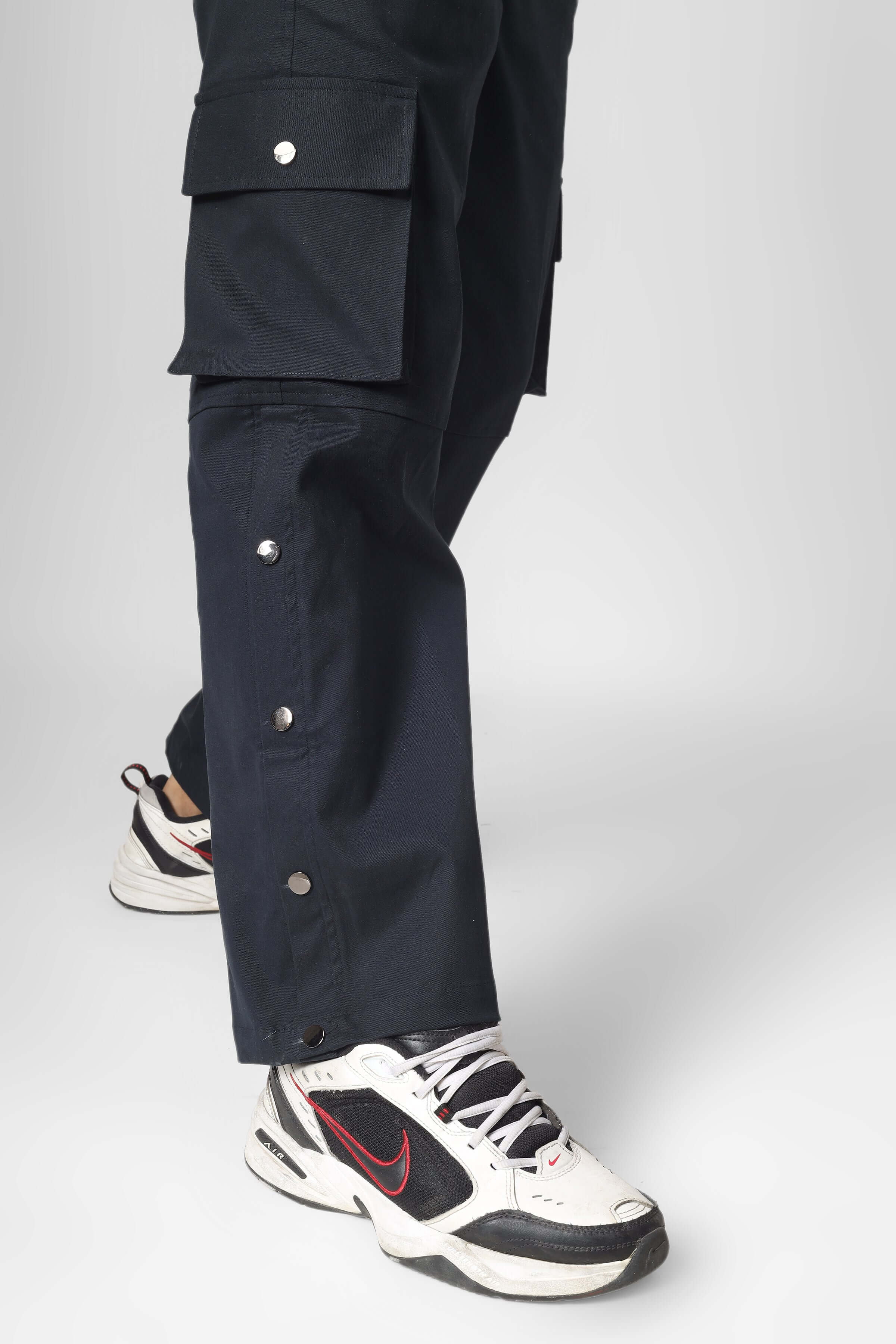Oxford blue cargo pants with 6 pockets, tailored by DUDS, displayed with sporty sneakers. Customizable fit available.
