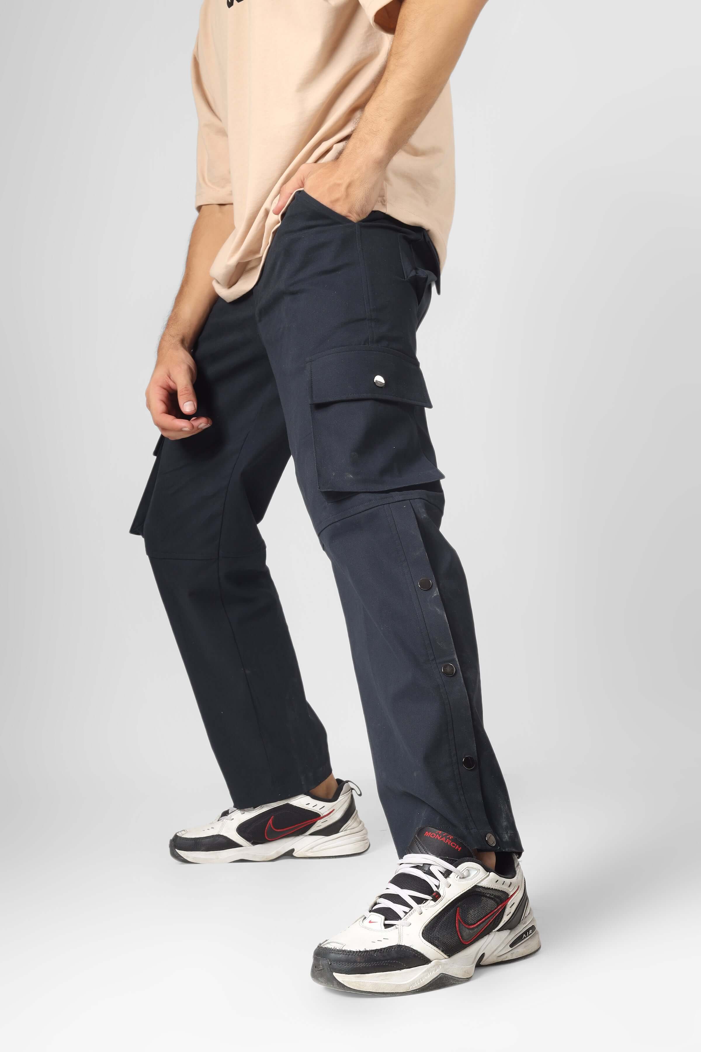Model wearing Oxford blue cargo pants with six pockets, showcasing a casual outfit with sneakers.
