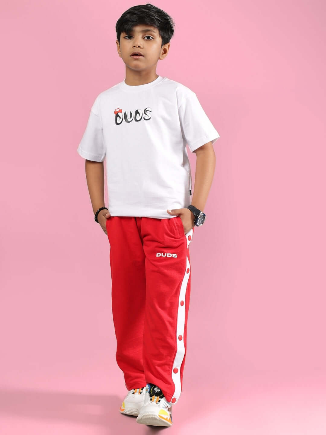 Child wearing PALOMA CO-ORD FOR BOYS & GIRLS WHITE RED outfit, featuring white t-shirt and red pants with bold detailing.