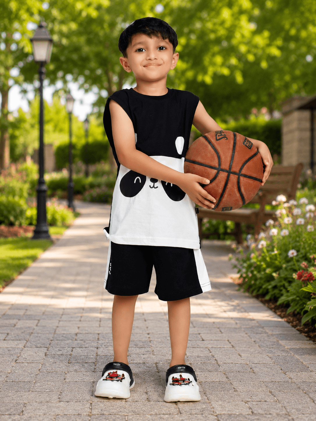 PANDA POP COOL SHORTS FOR BOYS GIRLS BLACK worn by a boy holding a basketball in a park setting.