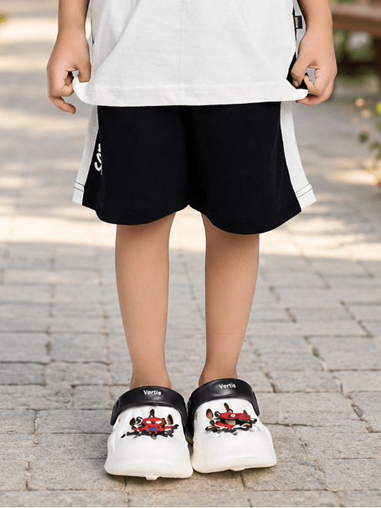 PANDA POP COOL SHORTS FOR BOYS GIRLS BLACK worn by a child with stylish shoes on a pathway.