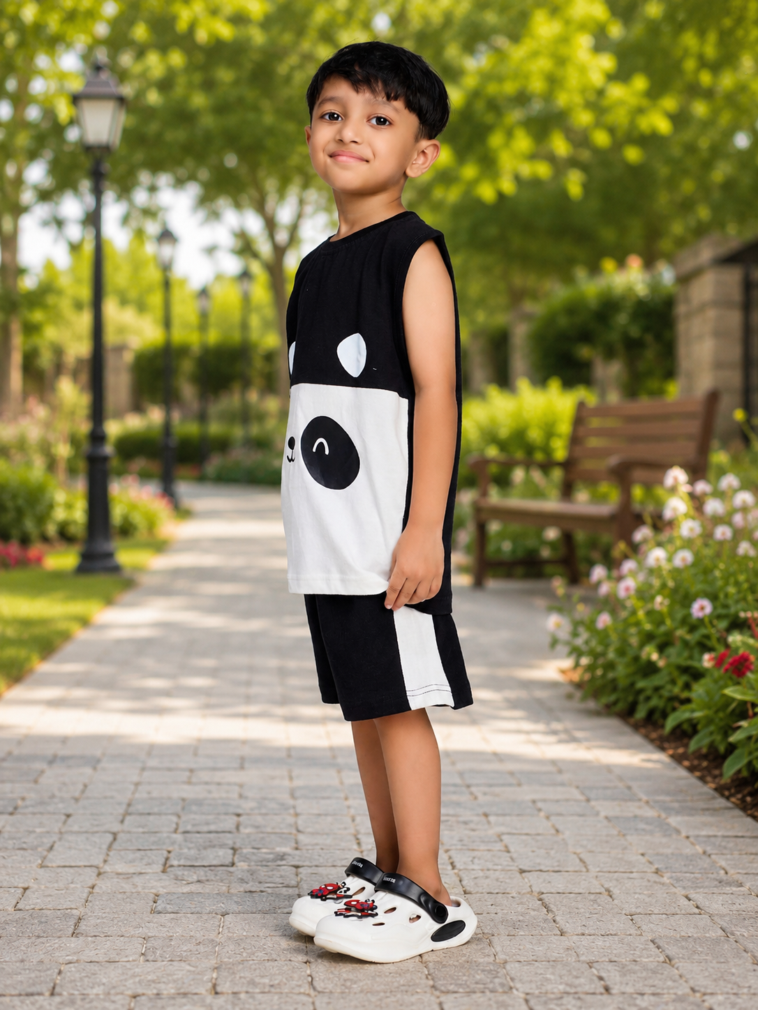 PANDA POP SLEEVELESS CO-ORD FOR BOYS GIRLS BLACK WHITE worn by a boy outdoors in a garden setting.