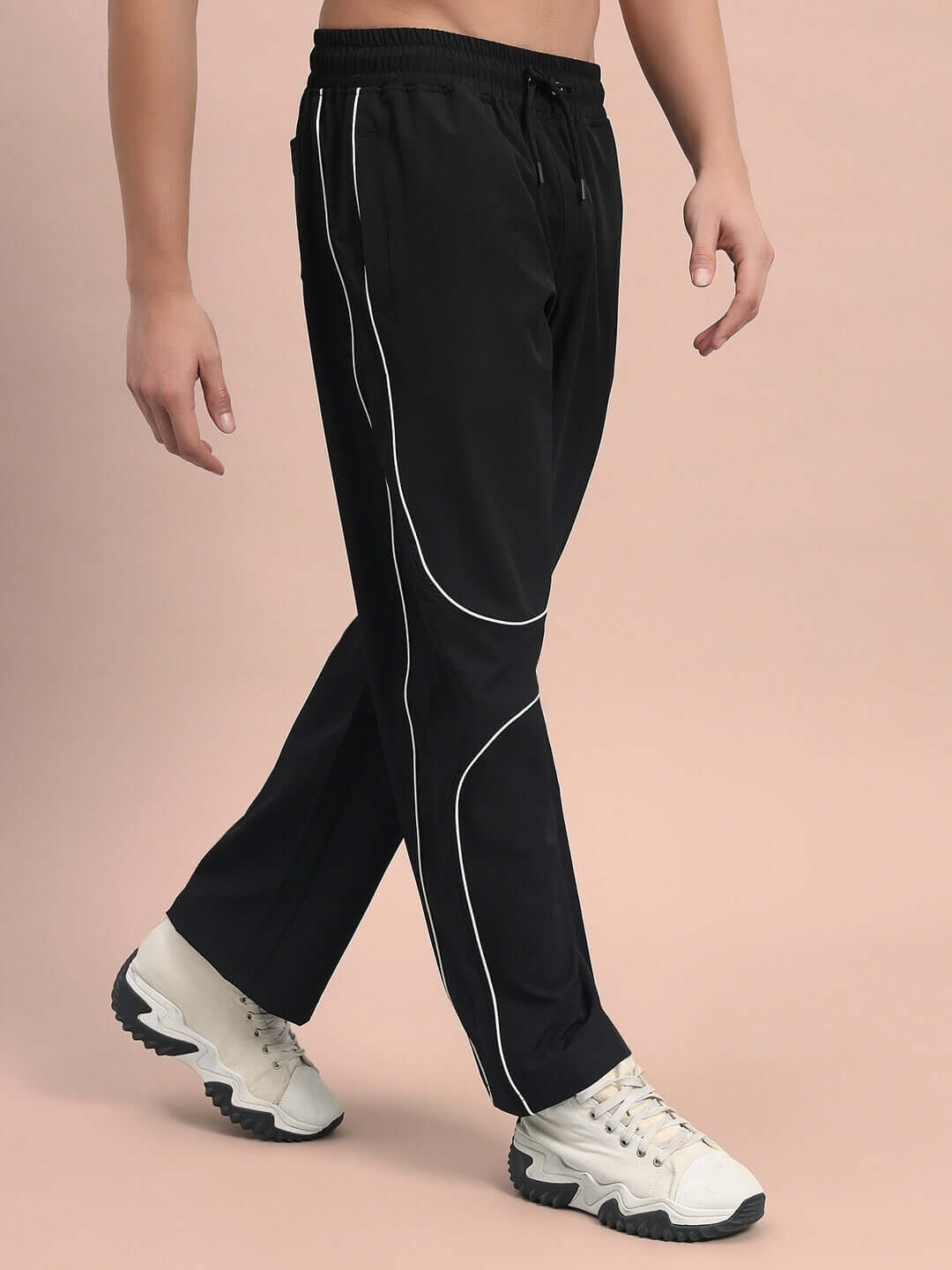 Model wearing black parabolic parachute cargo pants with white trim, showcasing a stylish design with custom fit option available.