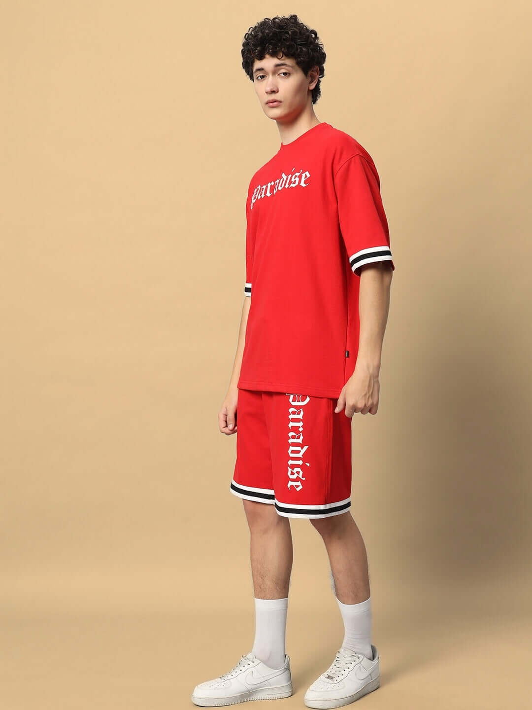 Model wearing a red Paradise colorblock co-ord set made of premium cotton French terry lycra, featuring a relaxed fit and sporty design.