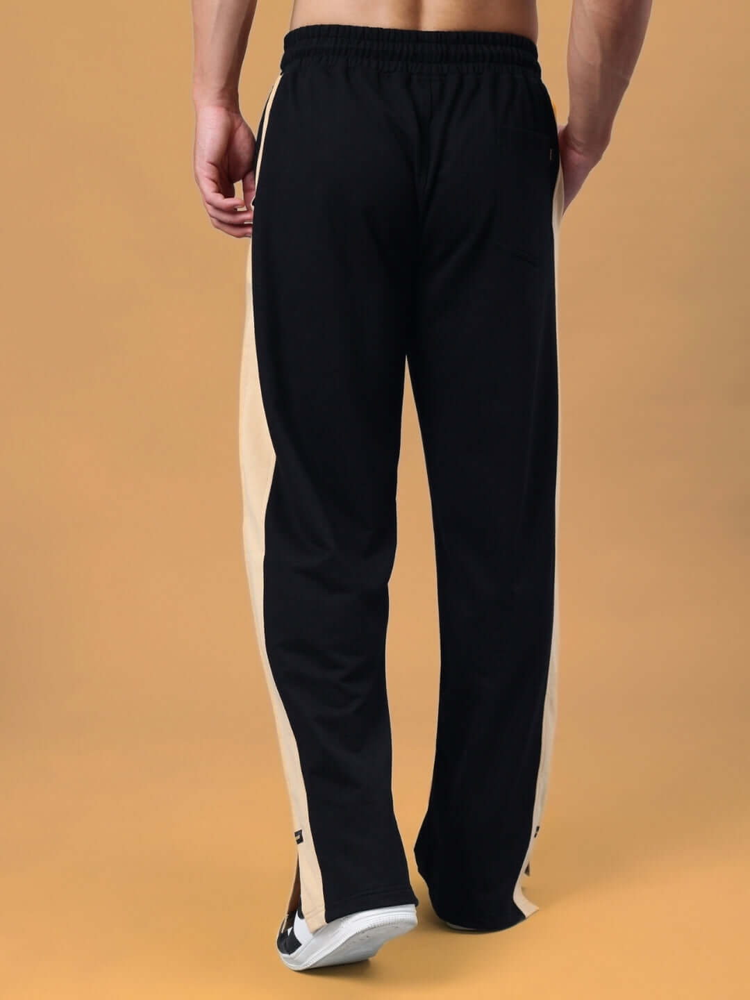 Back view of Paradise Side Slit Joggers in black and beige, made to order by DUDS, showcasing premium craftsmanship and style.