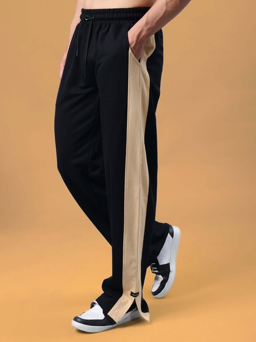 Model wearing Paradise Side Slit Joggers in black-beige, featuring an adjustable waist and beige side slit accent.