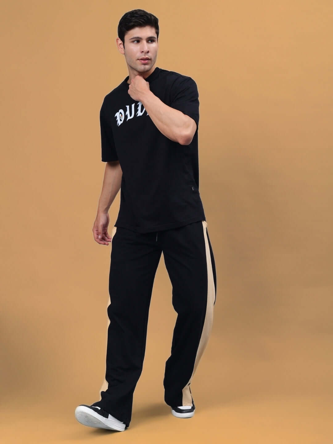 Model wearing Paradise Side Slit Joggers in black-beige by DUDS, showcasing stylish comfort with customizable size options.