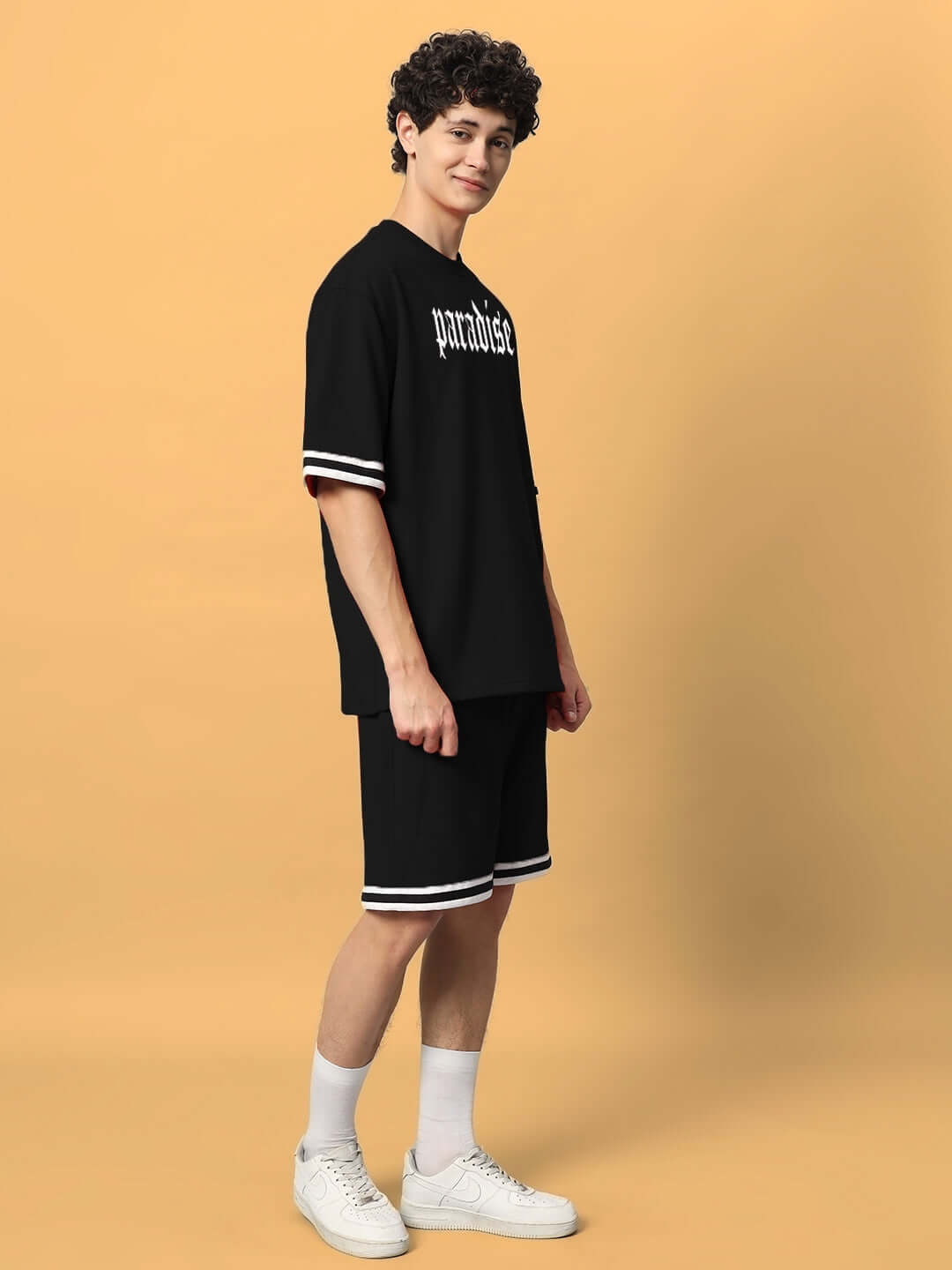 Man wearing Paradise Colorblock Co-Ord Set in black, featuring premium cotton fabric, contrasting white stripes, and sporty design.