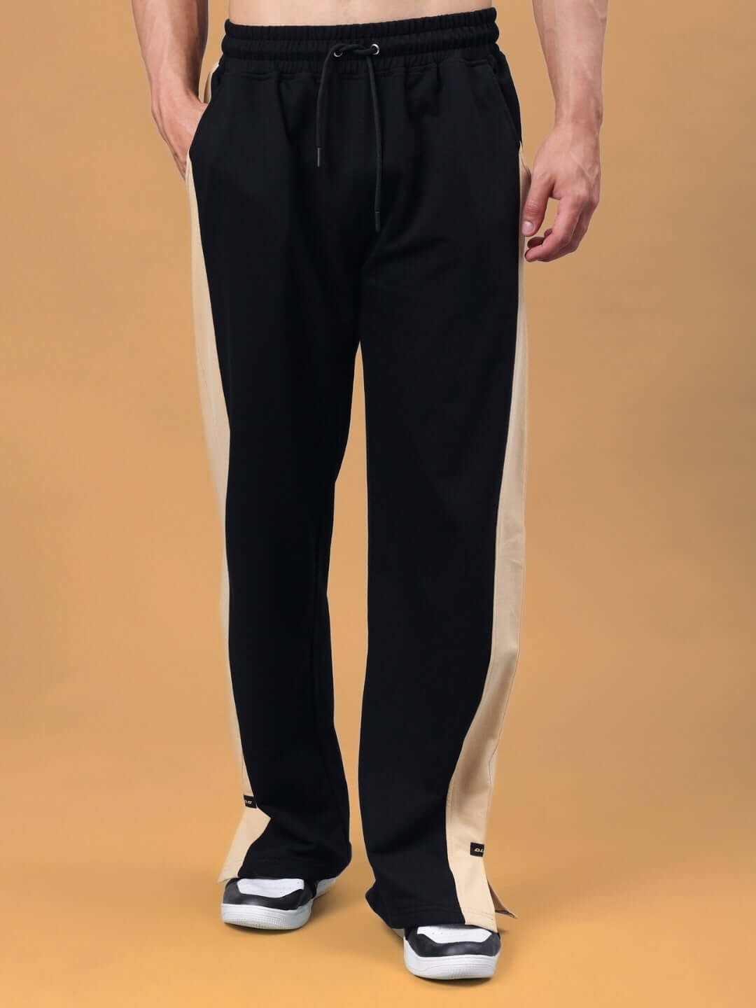 Black-beige Paradise side slit joggers with customizable fit, displayed on a model, showcasing DUDS' tailored craftsmanship.