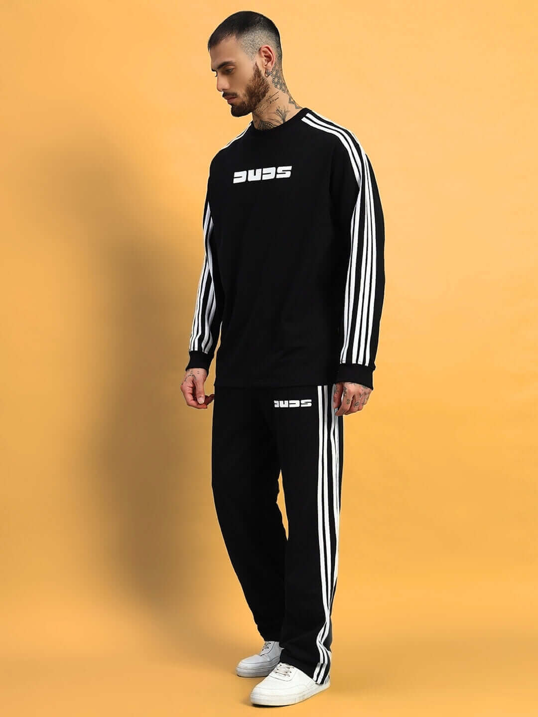 Model wearing PARKA JOGGER in black by DUDS, featuring a comfortable fit with white stripes, made to order by skilled tailors.