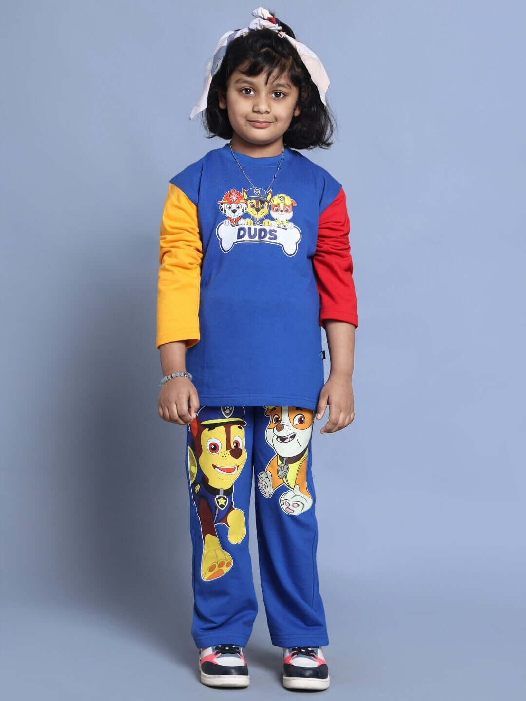 Child wearing a blue Paw Patrol oversized co-ord set with colorful sleeves, featuring cartoon characters on relaxed fit joggers.