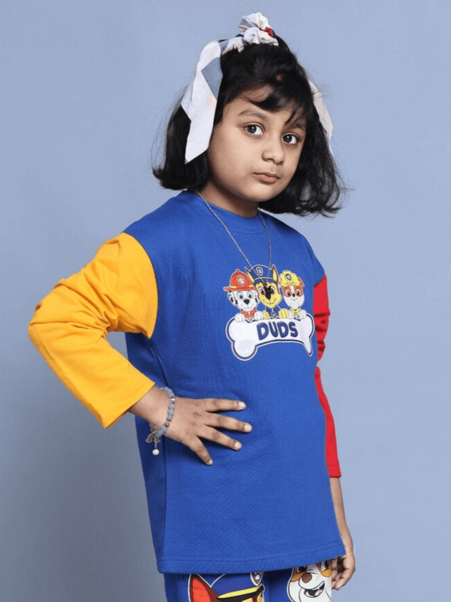 Child wearing a blue Paw Patrol over-sized sweatshirt with colorful sleeves, featuring popular characters. Ideal for boys and girls.