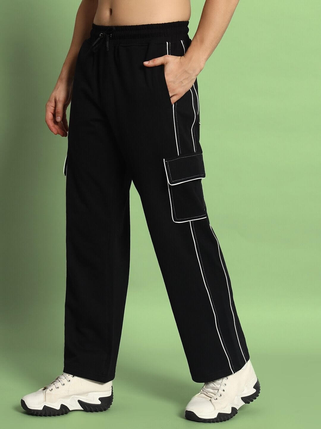 Black cargo pants with contrast stitching, made-to-order by DUDS, featuring pockets and customizable fit options on green background.