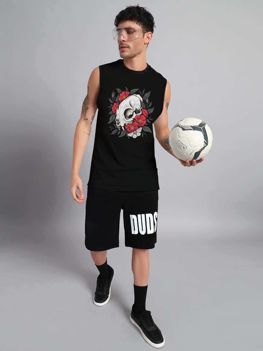 Man wearing black Peonies Skull Co-Ord Set, holding a soccer ball, featuring skull and floral design, cotton blend fabric.