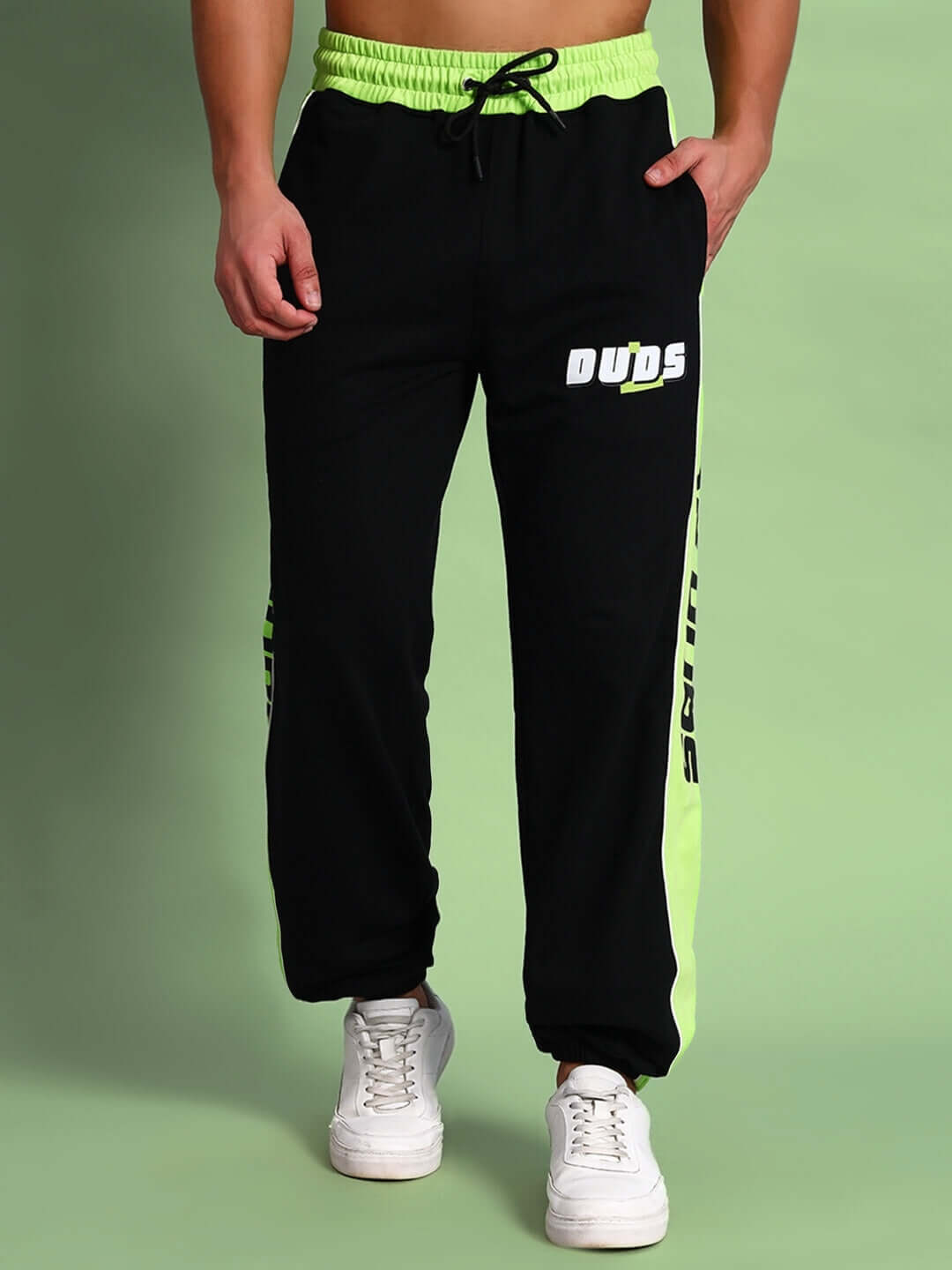 Black joggers with neon green accents by DUDS, featuring custom fit option, made by experienced tailors, perfect for active wear.