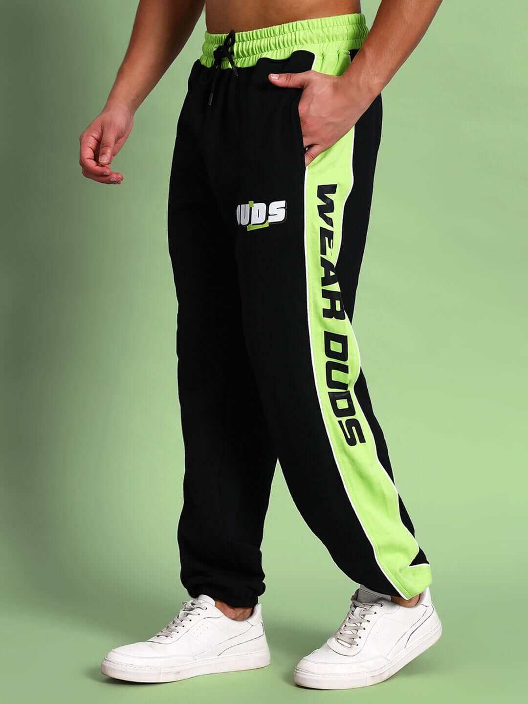 Model wearing black neon-green Peppy Joggers with "WEAR DUDS" text on side, showcasing athletic fit and style.
