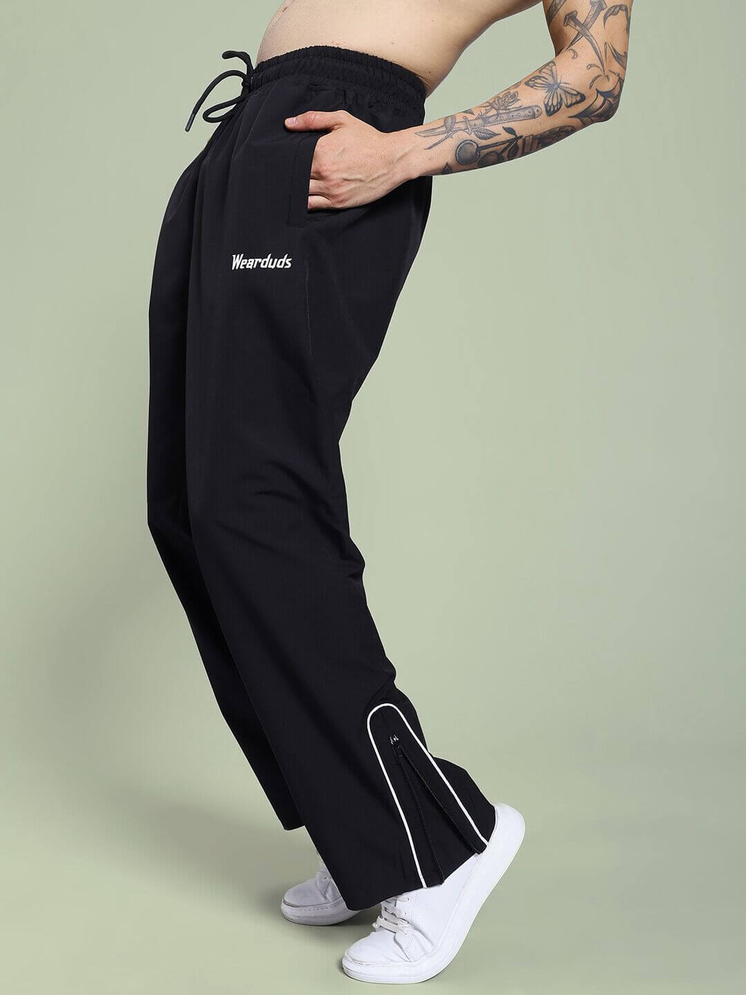 Side view of model wearing PERFACT RELAXED-FIT JOGGER BLACK with tattoos, showcasing comfortable fit and style.