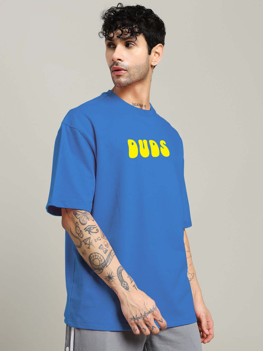 Model wearing blue oversized t-shirt with yellow 'DUBS' text, made from premium cotton blend, ideal for casual wear. Made in India.