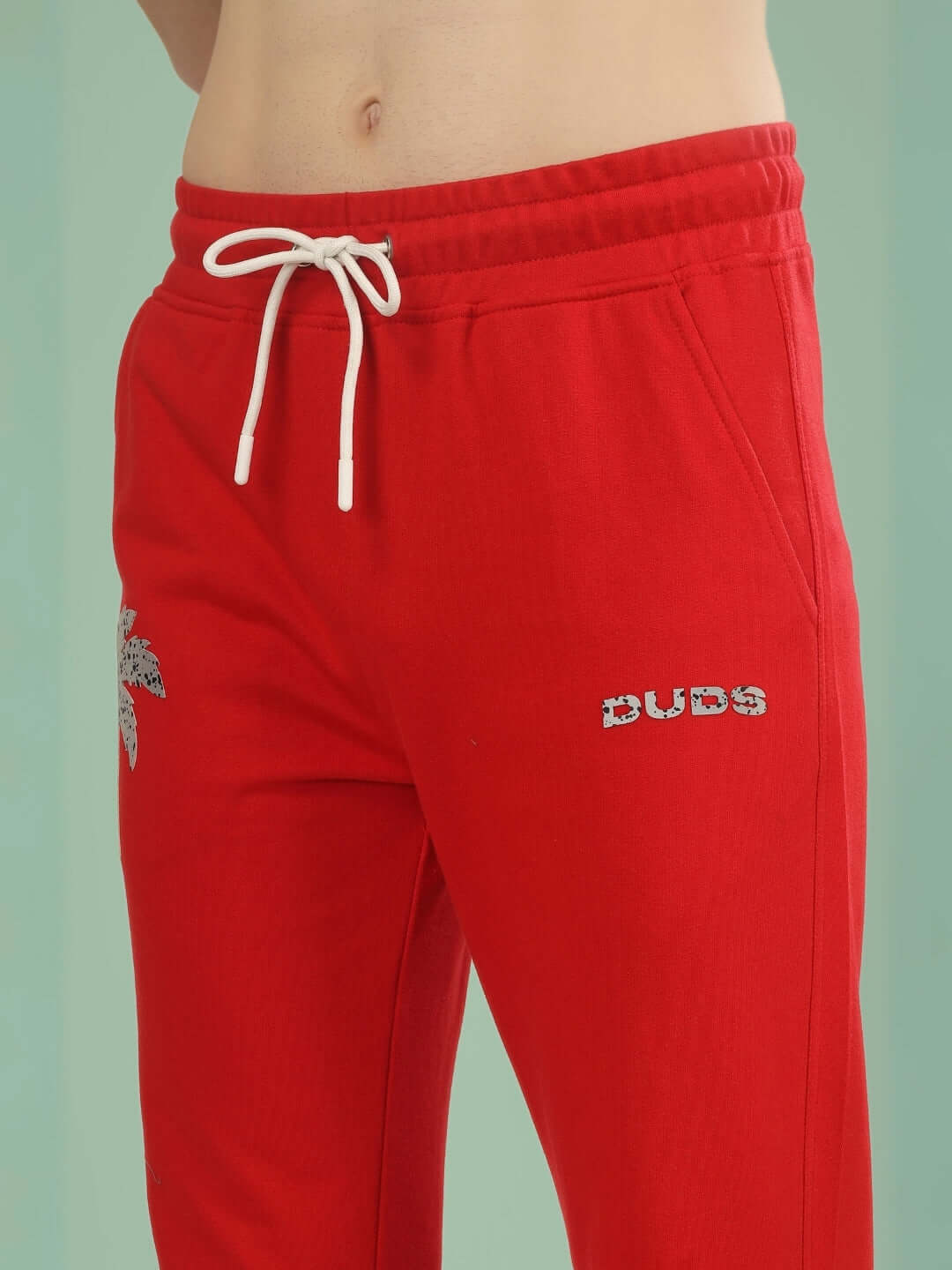 Red Phoenix digital printed joggers with drawstring waist and DUDS logo, showcasing tailored craftsmanship and custom fit option.